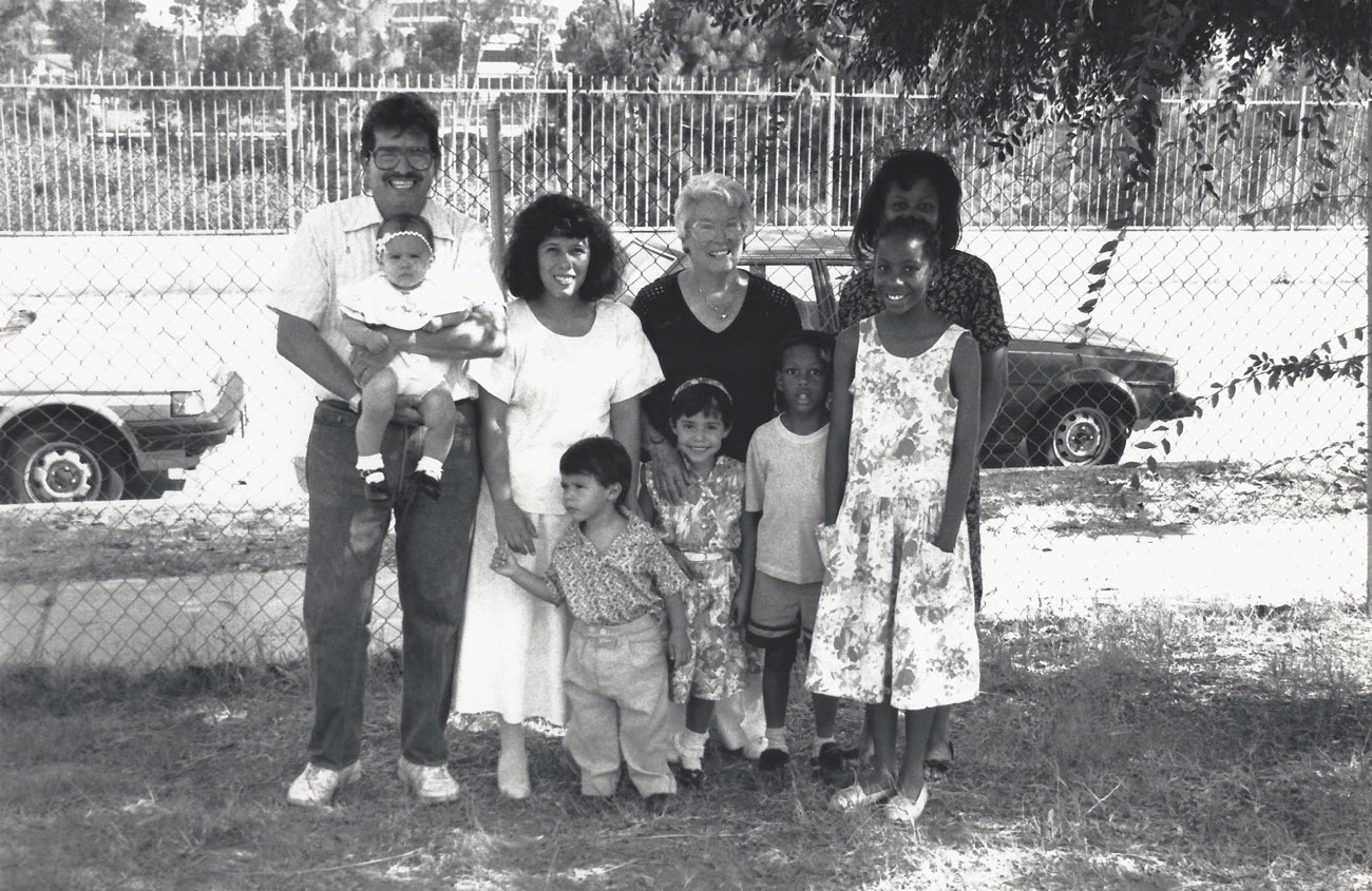 Black and white old picture of Phyllis and her family posting in the backyard.