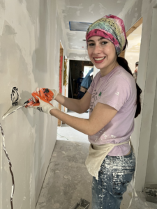 Young girl smiling into the camera while drilling.