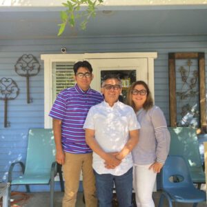Family, husband, wife, and son standing in front of their new ADU home.