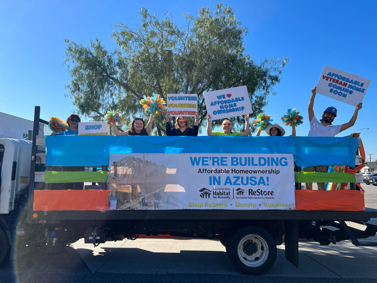 Kids and adult in a truck holding signs.