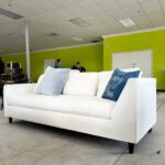 Long white couch on showroom floor.