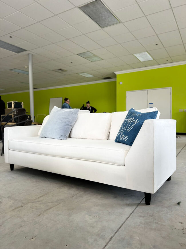 Long white couch on showroom floor.