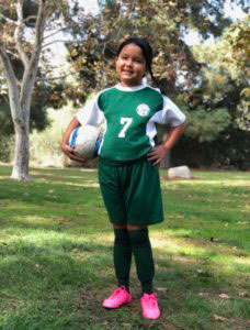 Young girl, in a soccer uniform.