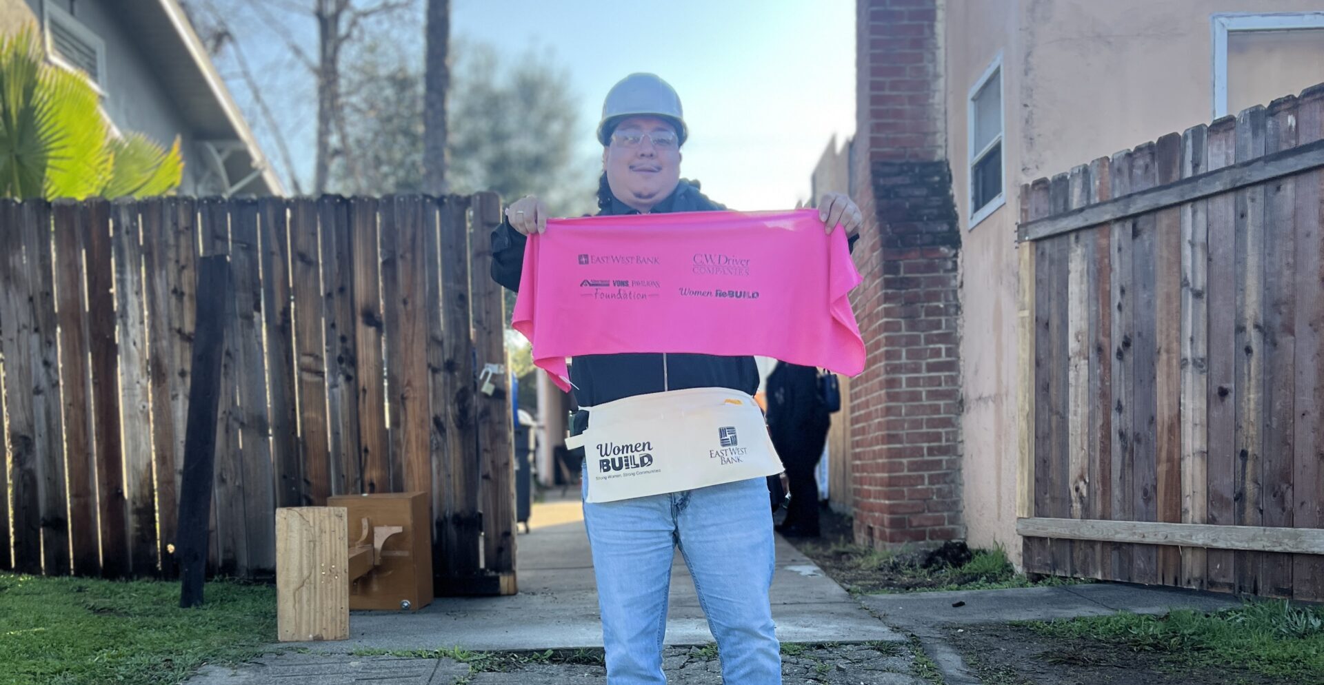 woman at women build holding up pink towel