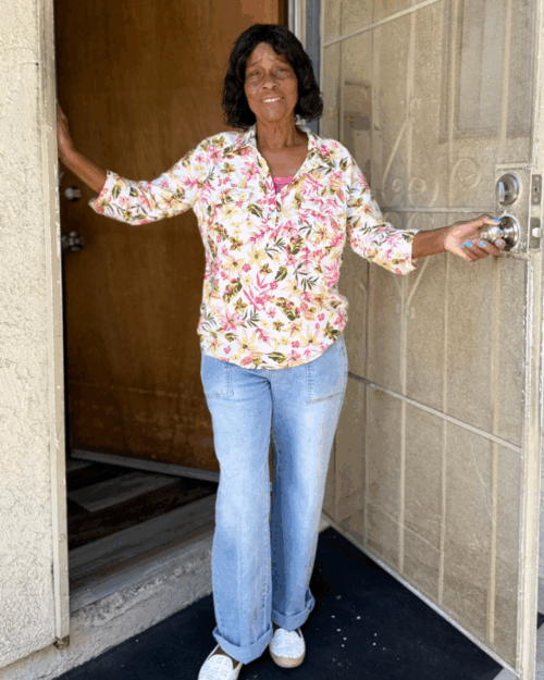 lady standing in her doorway smiling