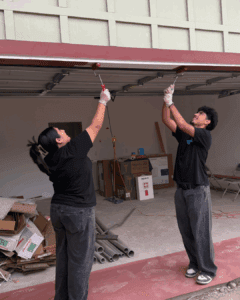teenage girl and boy painting trim with red paint 