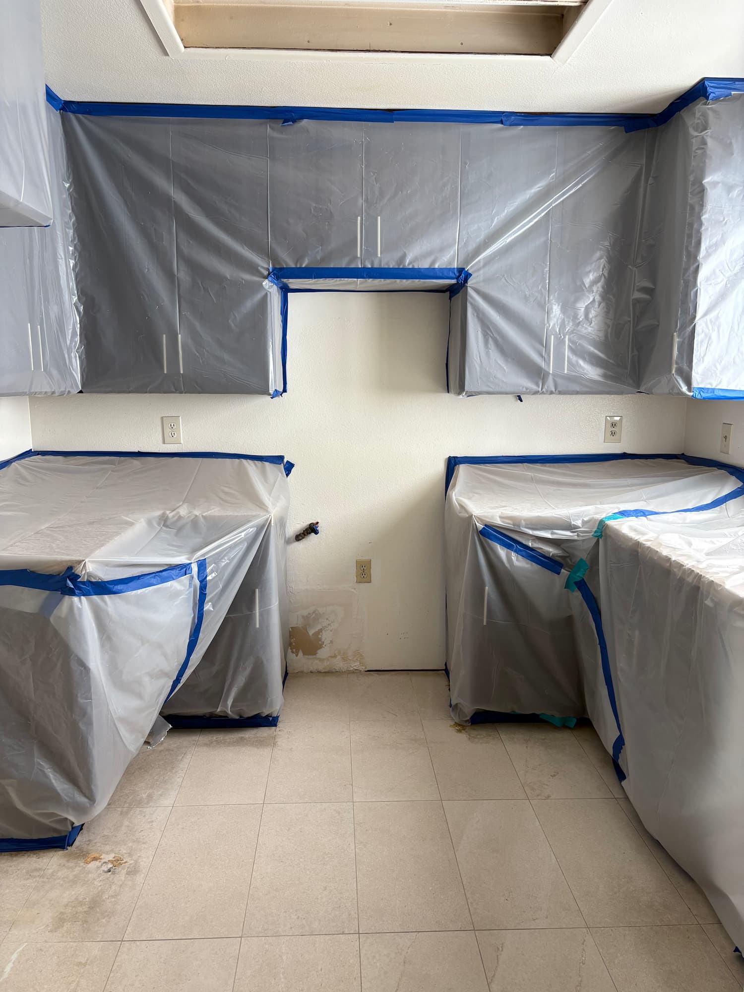 Home kitchen with cabinets wrapped in protective plastic