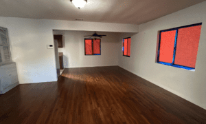 empty living room, windows taped up