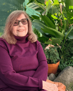 woman sitting with a garden behind her