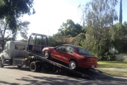 car being loaded on a tow truck being donated to cars for homes