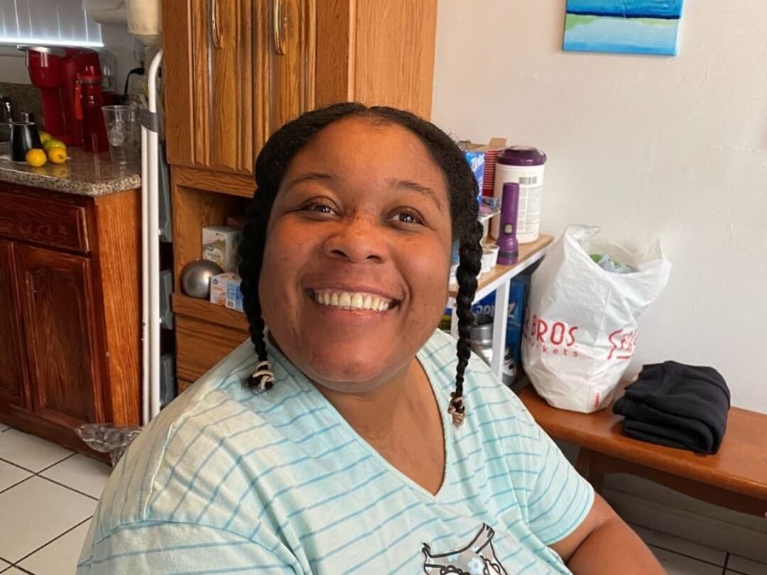 A woman smiling and wearing a blue shirt