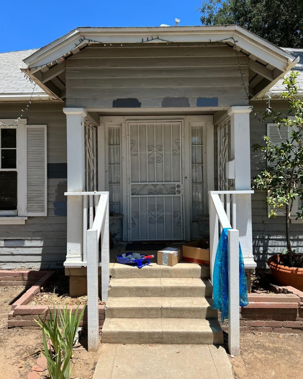 Front porch of a house that has fading paint