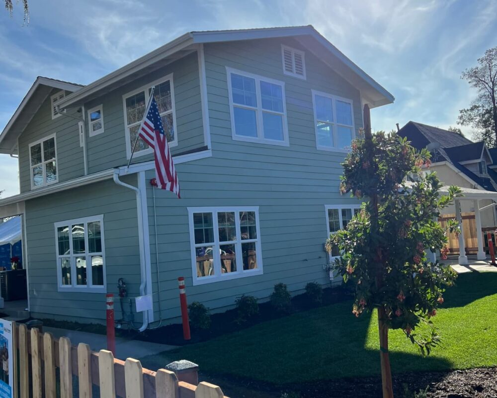 Finished Howard-Navarro home with white trim and an American flag