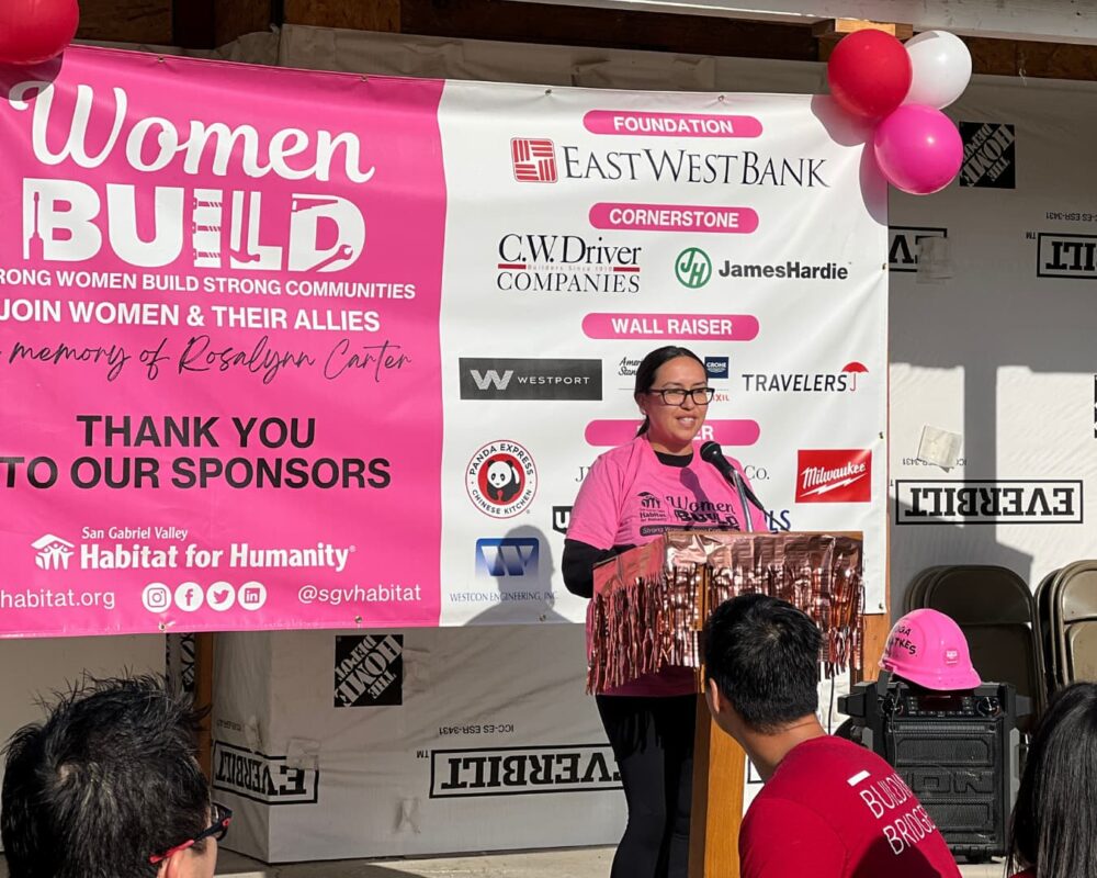 Woman in a pink shirt smiling behind a podium
