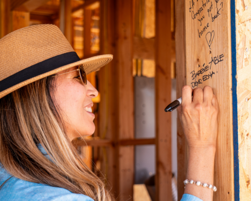 guest signing a beam with a message
