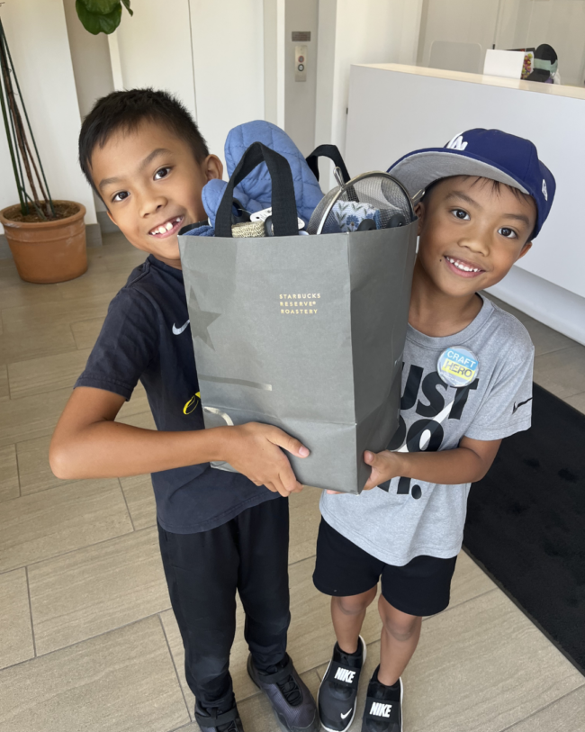 youth volunteers two young boys smiling holding a welcome home basket