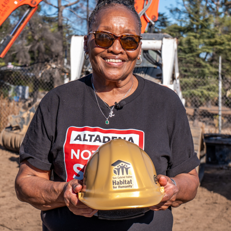 homeowner posing with gold hard hat