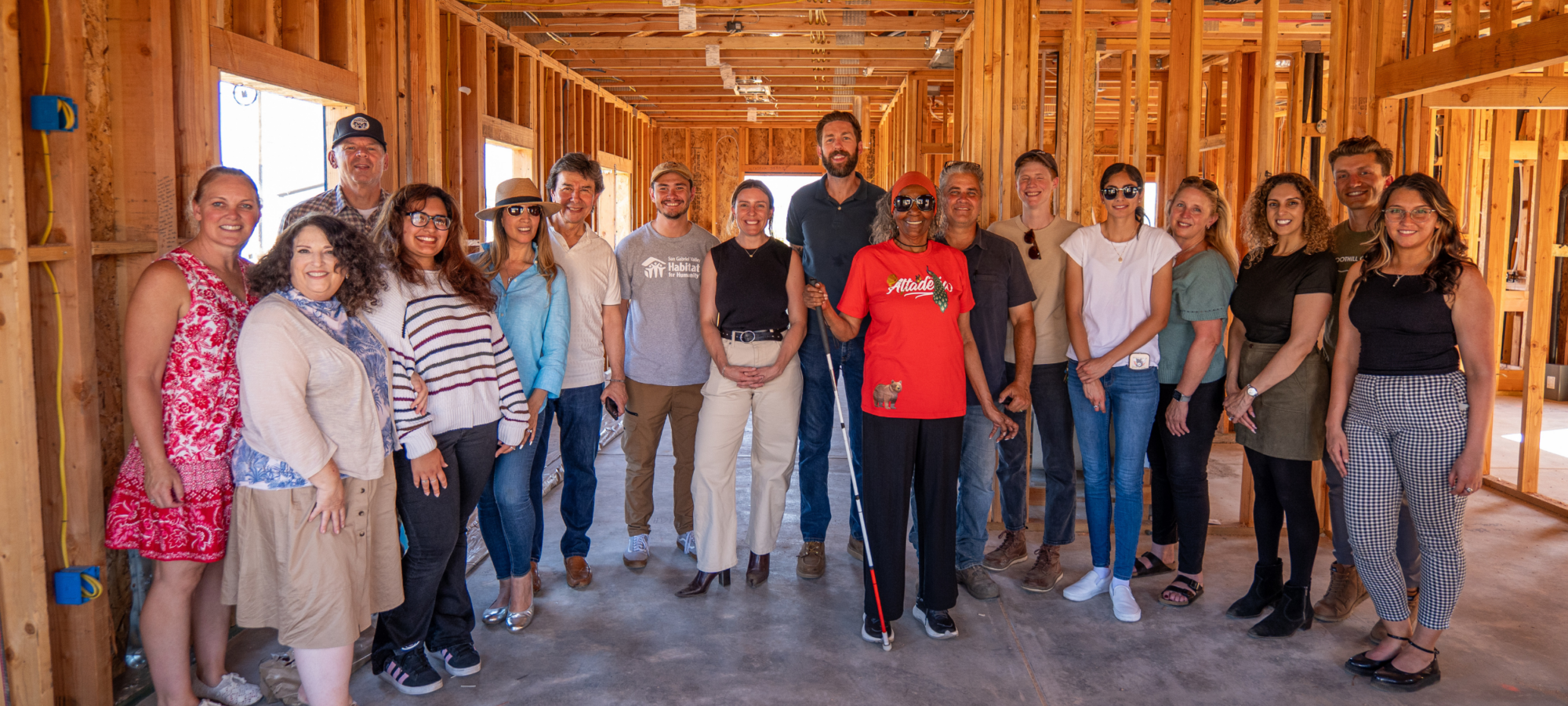 SGVHabitat staff, friends and family stand with homeowner at a wall signing event.