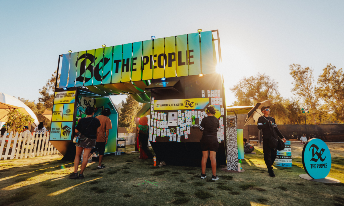 people gathering at the be the people activation with the sun behind it.