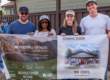 group standing holding a banner featuring the home that will be built in the future