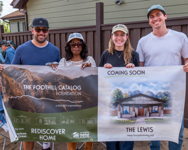 group standing holding a banner featuring the home that will be built in the future