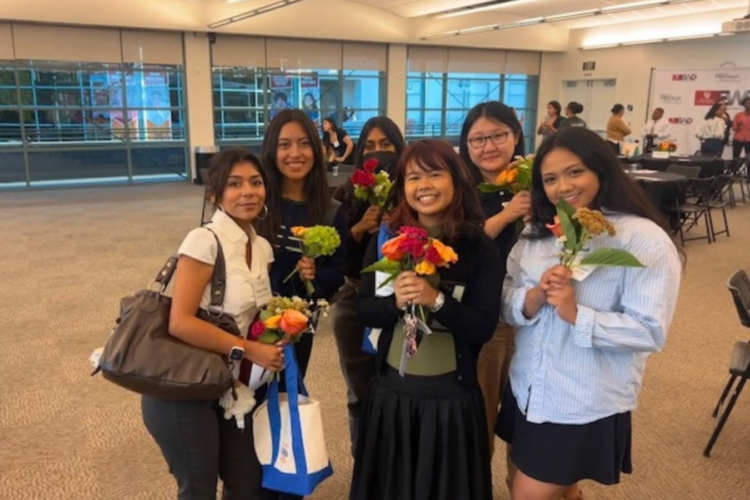 students posing with flowers